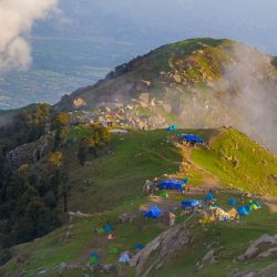 Triund hilltop with panoramic views of the Dhauladhar Range, a must-visit trekking destination in Himachal Pradesh, easily accessible by taxi.